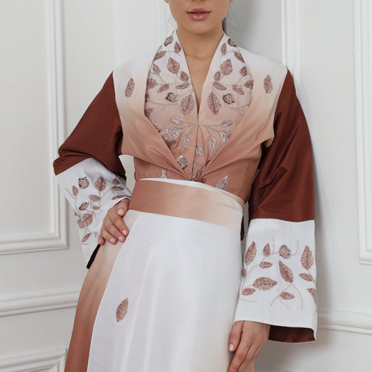 Woman wearing a brown and white outfit with floral patterns on a white background